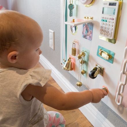 a toddler engages with a diy busy board