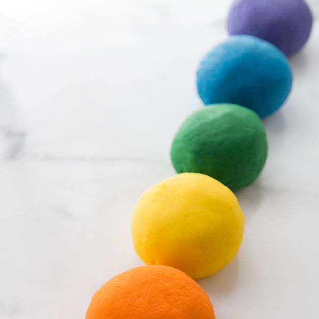 a series of different colored play dough balls are photographed in a diagonal line