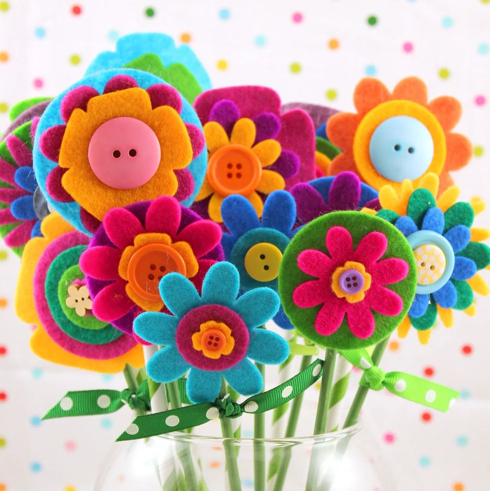 A bouquet of felt flowers is placed in a transparent vase. This project is perfect for household chores, as a great activity for children