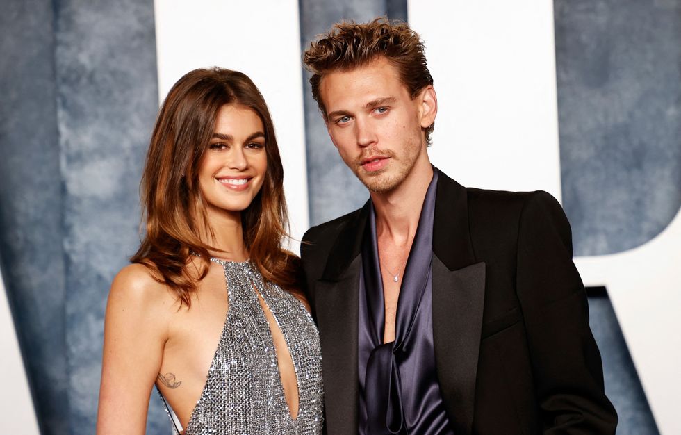 austin butler embracing girlfriend kaia gerber as the two smile for a photograph together