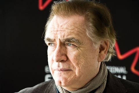brian cox wearing a brown scarf and looking off camera