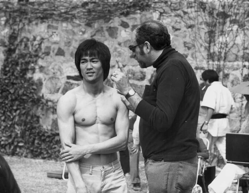 bruce lee smiling and talking to a film producer