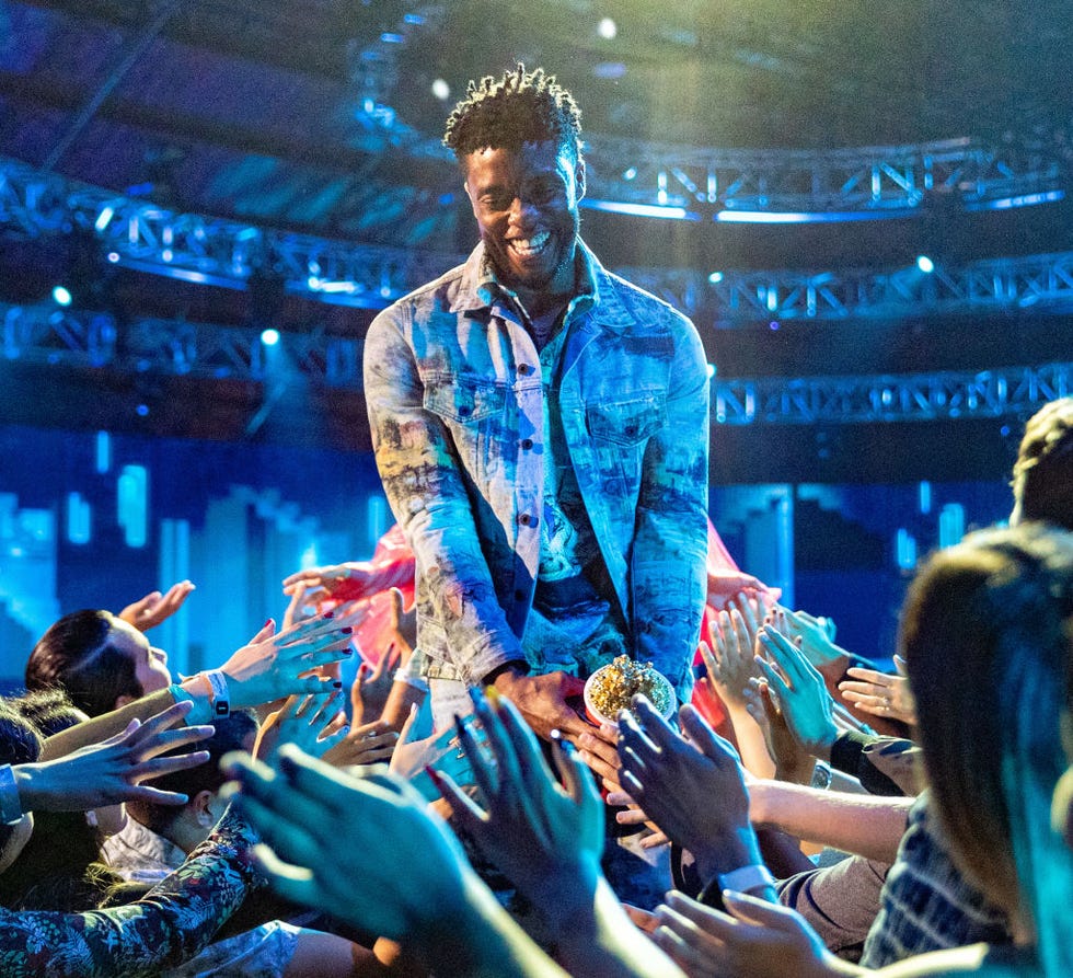 chadwick boseman smiles as fans reach out hands to him
