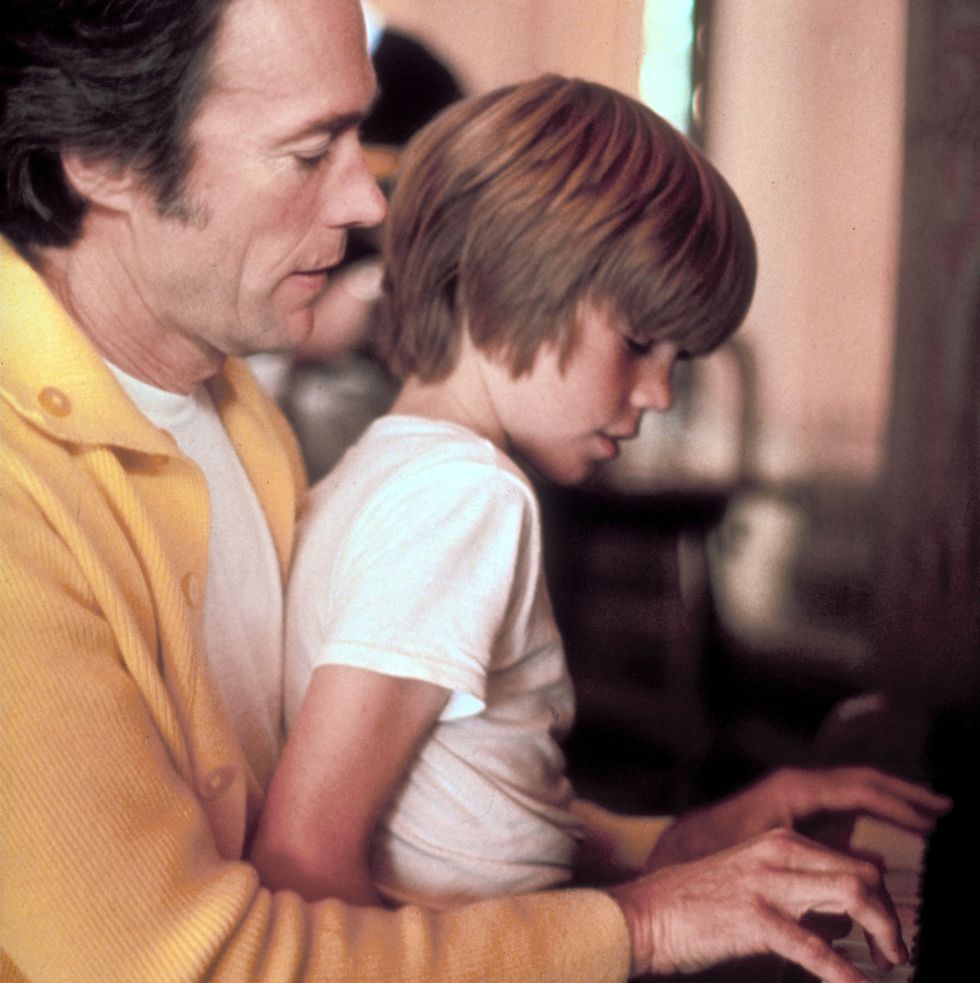 clint eastwood plays piano while kyle eastwood sits on his lap