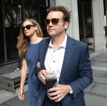 danny masterson wearing sunglasses and holding a coffee as he walks to a courtroom with his wife