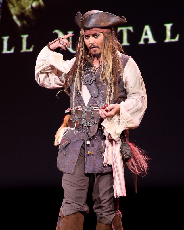 johnny depp gesturing to an audience while dressed as pirate jack sparrow