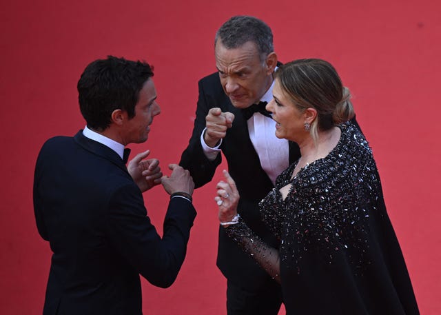 tom hanks pointing while he and wife rita wilson speak to a red carpet worker