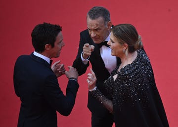 tom hanks pointing while he and wife rita wilson speak to a red carpet worker