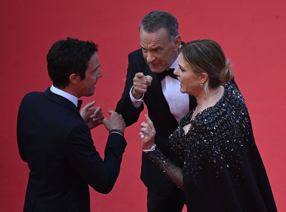 tom hanks pointing while he and wife rita wilson speak to a red carpet worker