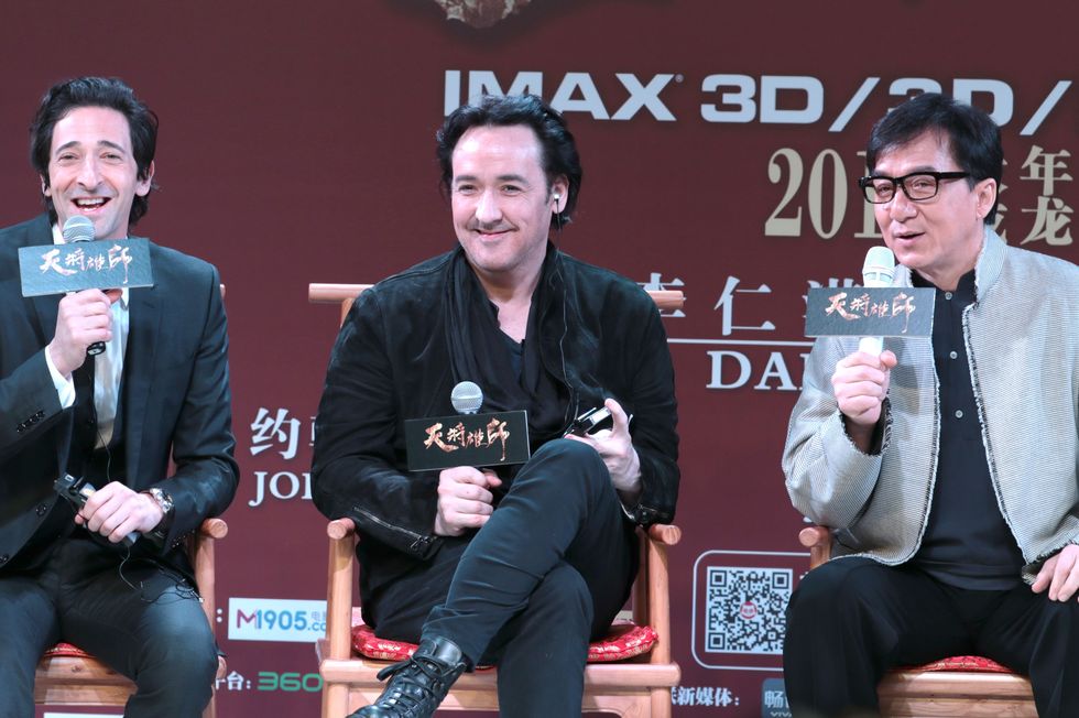 jackie chan sits in the middle of adrien brody and john cusack