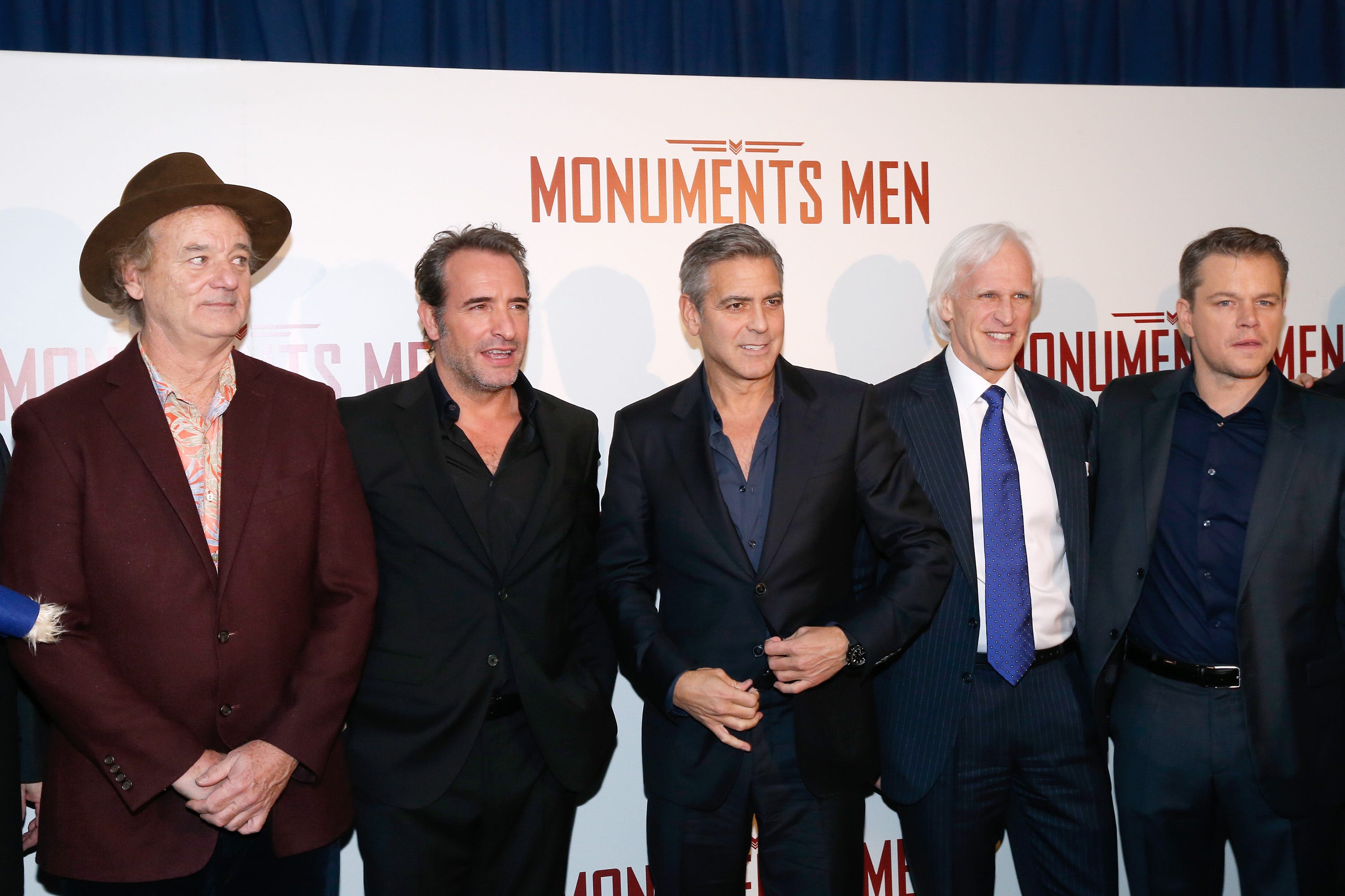bill murray, jean dujardin, george clooney, robert m edsel and matt damon stand in a line and pose for photos in front of a movie poster for monuments men