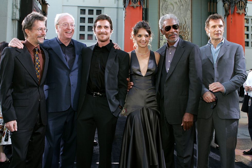 gary oldman, michael caine, christian bale, katie holmes, morgan freeman and liam neeson stand together and smile for a photo in formal attire