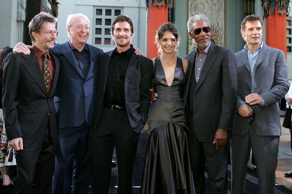 gary oldman, michael caine, christian bale, katie holmes, morgan freeman and liam neeson stand together and smile for a photo in formal attire