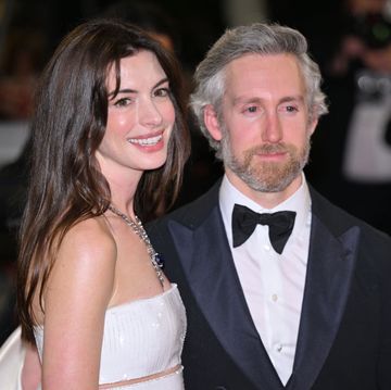 anne hathaway and her husband adam shulman posing on a red carpet together