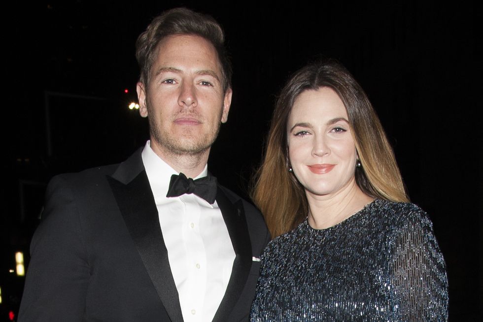 will kopelman, wearing a black tuxedo, and drew barrymore, wearing a gliterring blue dress and holding a purse, posing and looking directly into the camera