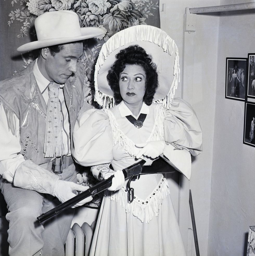 actress ethel merman shows actor ray middleton the winchester rifle annie oakley used in her 1887 european tour. the gun was loaned by mrs. spencer t. olin with special blanks for use in the 100th performance of the musical annie get your gun, in which merman plays oakley. musica and lyrics: irving berlin.