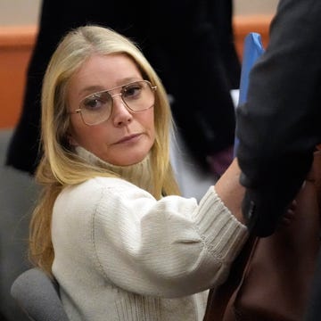 The Trial Of Gwyneth Paltrow In Her Ski Accident Lawsuit Begins gwyneth paltrow wearing a white turtleneck sweater and glasses, sitting in a courtroom and looking ahead, unsmiling