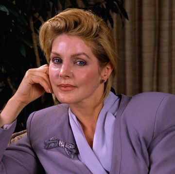 priscilla presley sitting on a chair in the thinking pose with her head resting on her hand