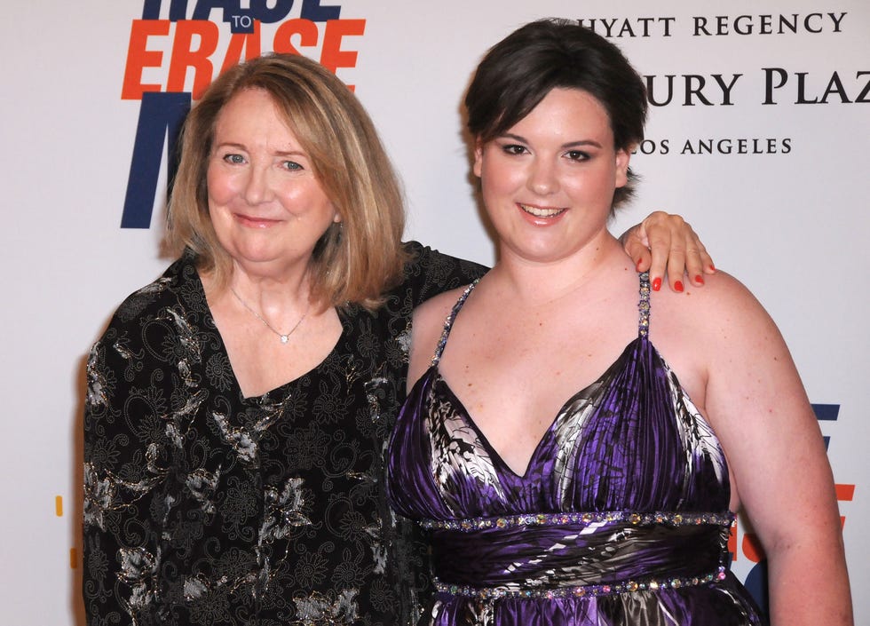 teri garr hugs molly oneil as both smile for photos, teri wears a black and silver formal outfit, molly wears a purple black and silver sleeveless dress