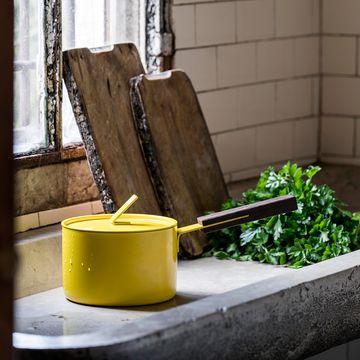 a yellow saucepan next to a window
