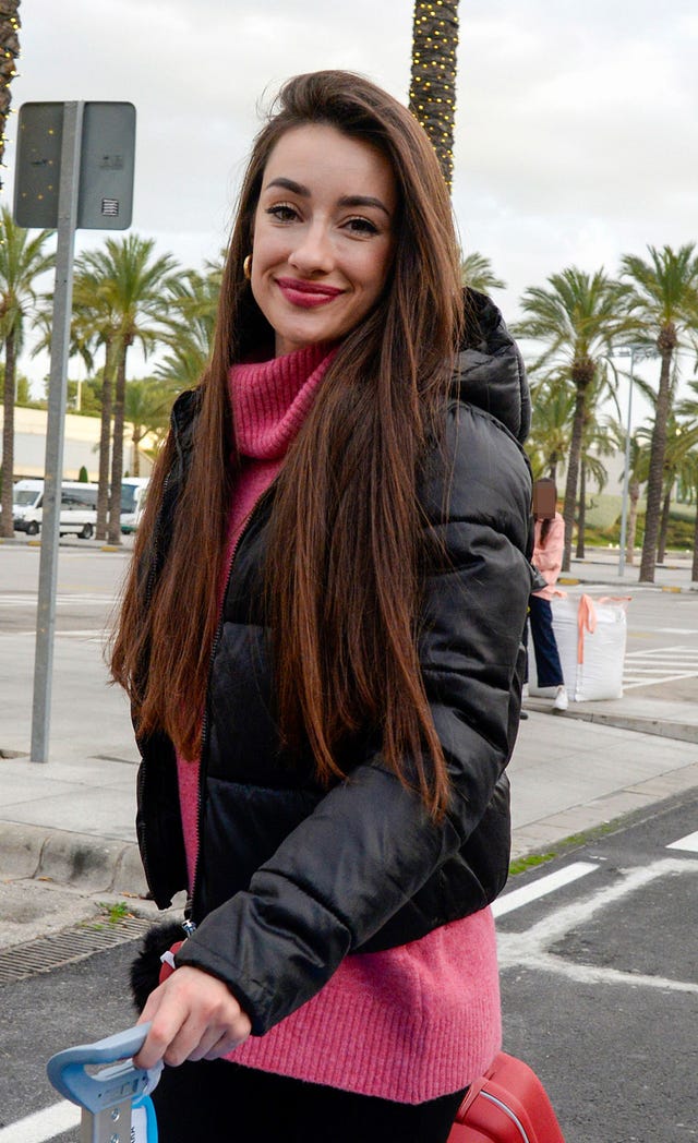 la influencer con abrigo y jersey fucsia