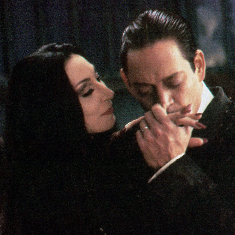 Morticia Addams gets a kiss from Gomez in a scene from 'The Addams Family,' a Good Housekeeping pick for best Halloween movies for kids morticia addams gets a kiss from gomez in a scene from 'the addams family,' a good housekeeping pick for best halloween movies for kids