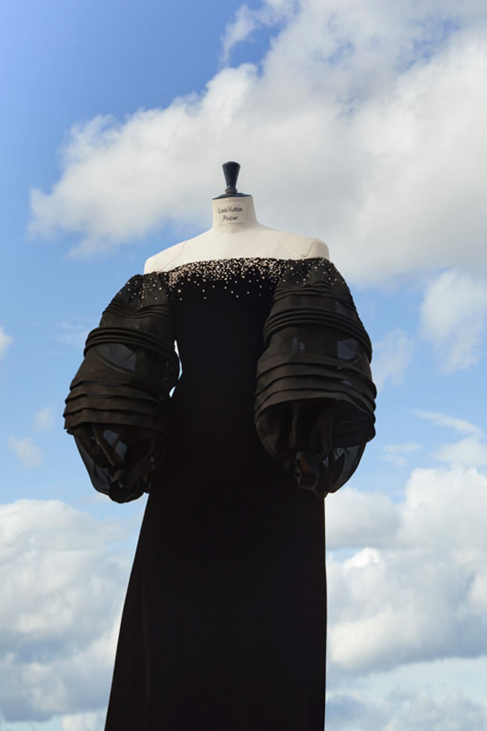 a statue of a person wearing a black suit and gloves