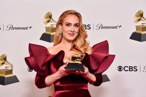 adele holding her grammy statuette for pictures