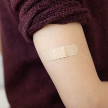 adhesive bandage on arm of a female after taking vaccine