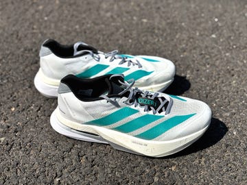 a pair of white adidas running shoes with blue stripes