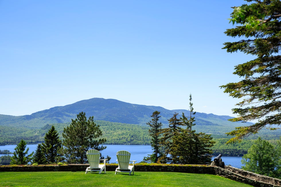 adirondack chairs on a lawn overlooking moosehead lake and mountains
