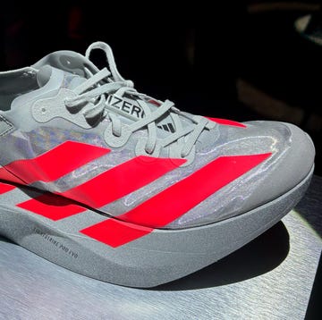 a grey and red striped adidas shoe a grey and red striped adidas shoe