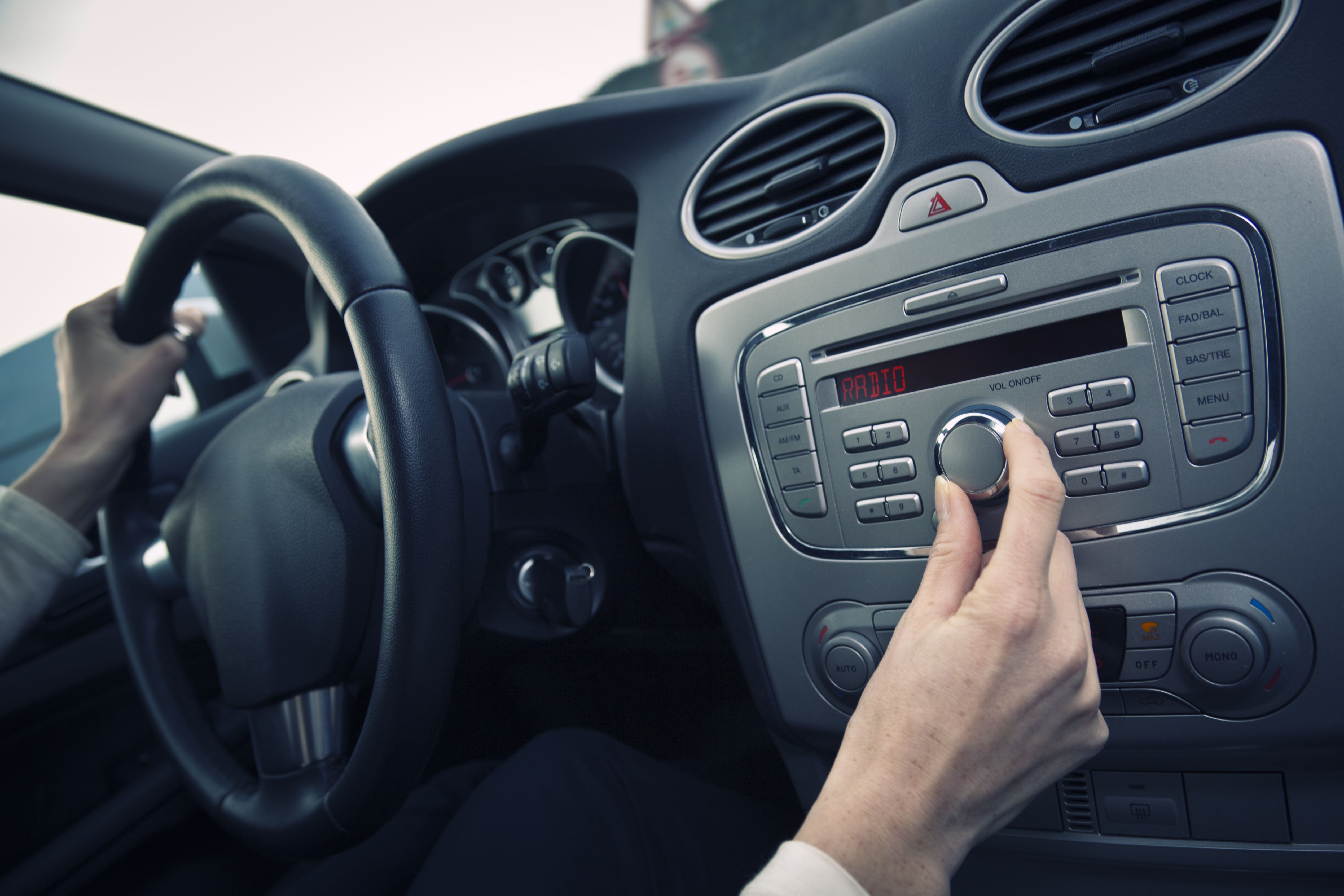 Woman Turning Up The Volume On The Car Radio Stock Photo