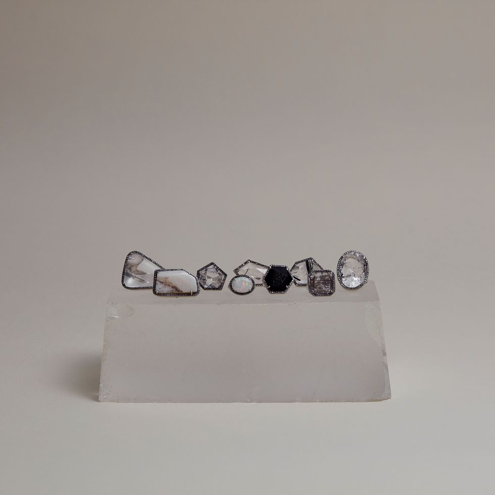 a white box with a group of silver and black rings on it