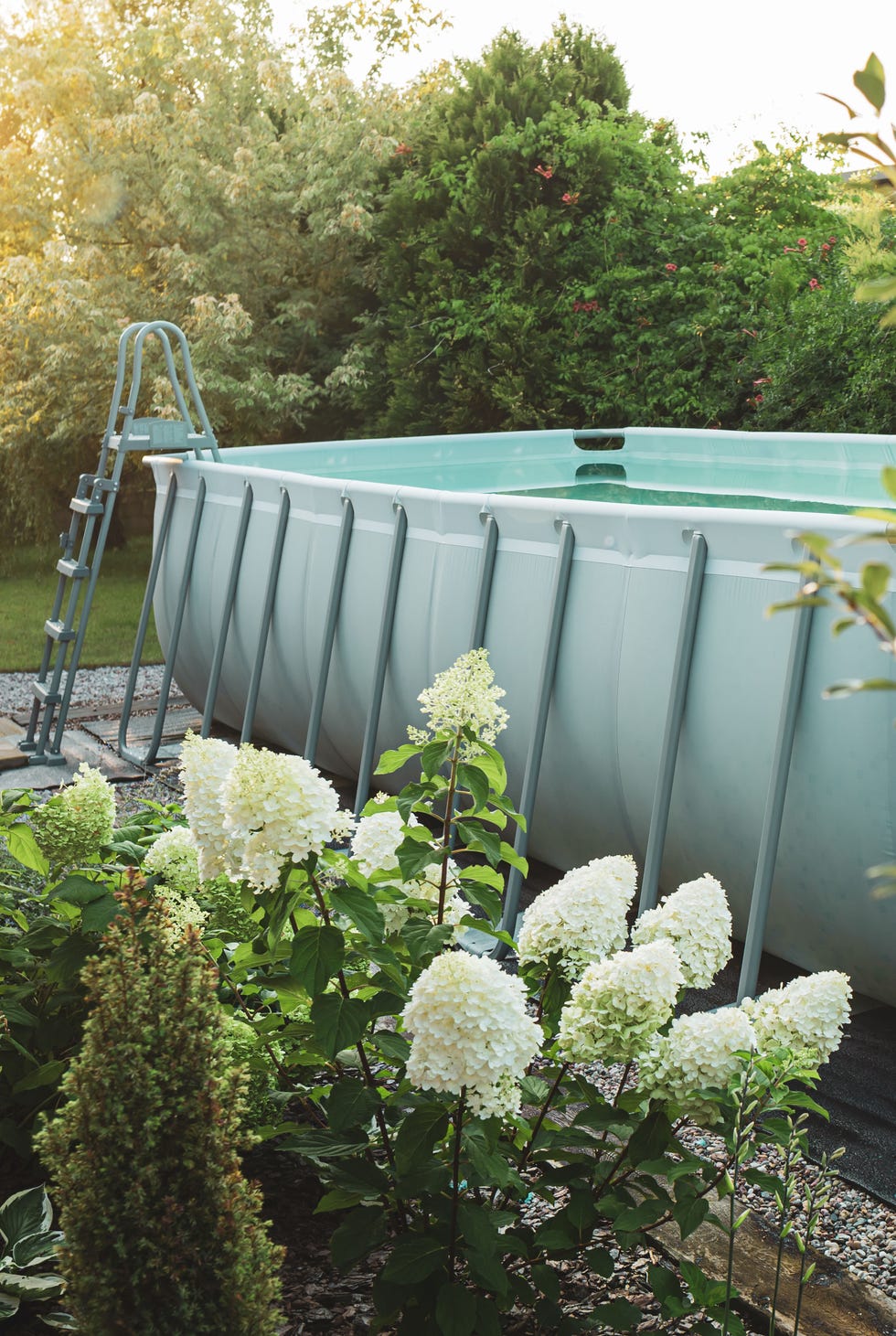 Above ground, rack swimming pool in the beautiful garden. Summer holiday recreation. long, above ground, rectangular, rack frame swimming pool outdoor in the beautiful garden nook summer holiday vacation and recreation