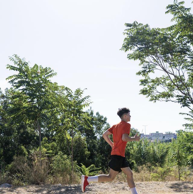 adolescent male jogging in a public park