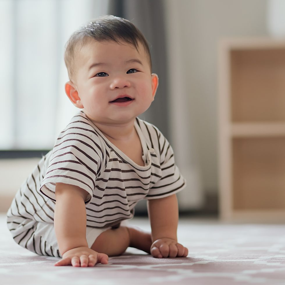 adorable baby boy crawling on the carpet floor