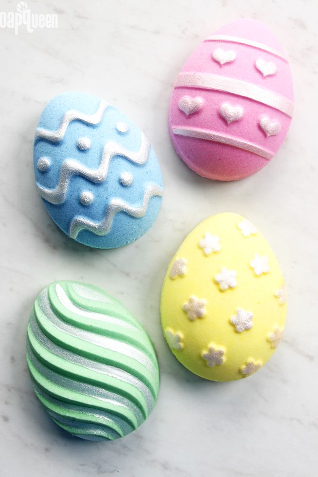 blue, pink, green, and yellow egg shaped bath bombs with decorative embellishments for adult easter egg hunt idea