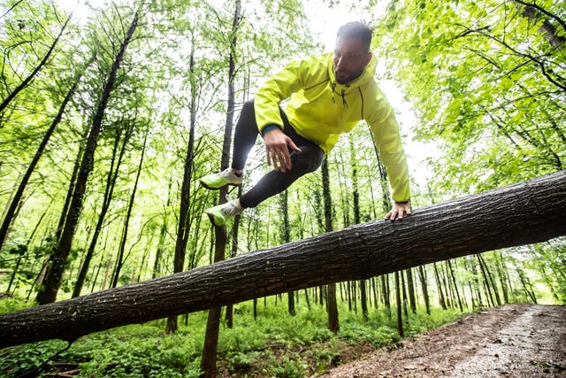 adult man running in forest in bad weather