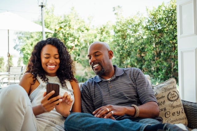 adult siblings looking at birthday wishes on a phone together