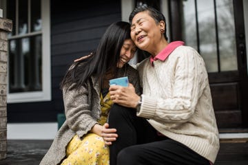 adult woman and senior mother talking on front porch