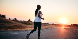 adult woman running on road at sunset