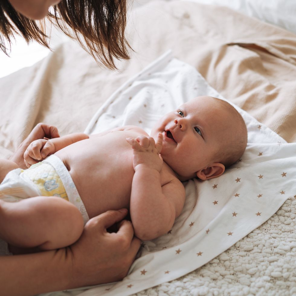 adult woman young mother with 2 3 month baby boy lying on white blanket at home