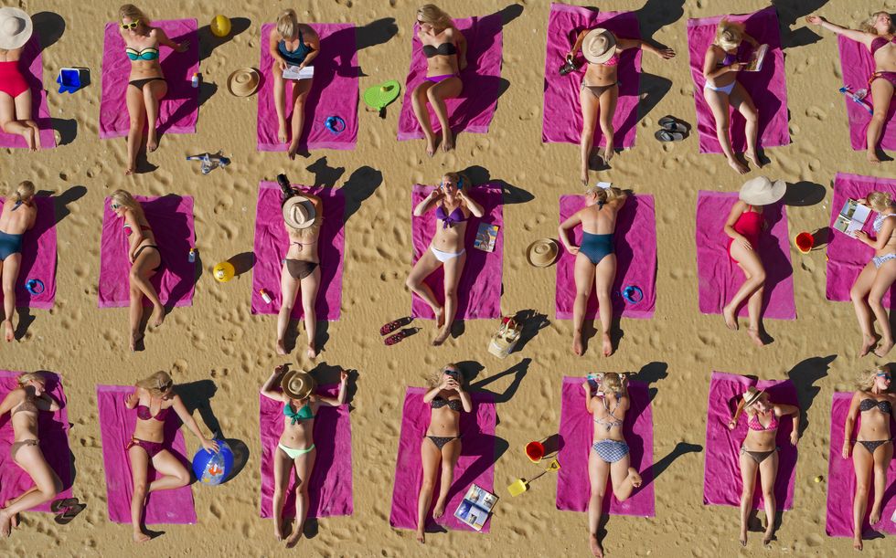 foto aérea de mulher duplicada tomando sol na praia