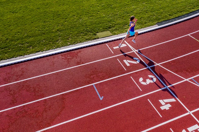 una chica entra en la línea de meta de una línea de atletismo