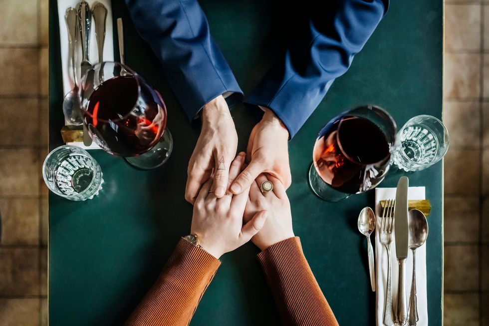 aerial view of couple holding hands at restaurant table