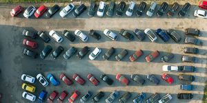 aerial view of many colorful cars parked on dealer parking lot for sale