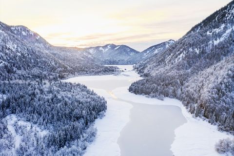 aerial view of snow covered landscape and frozen lake