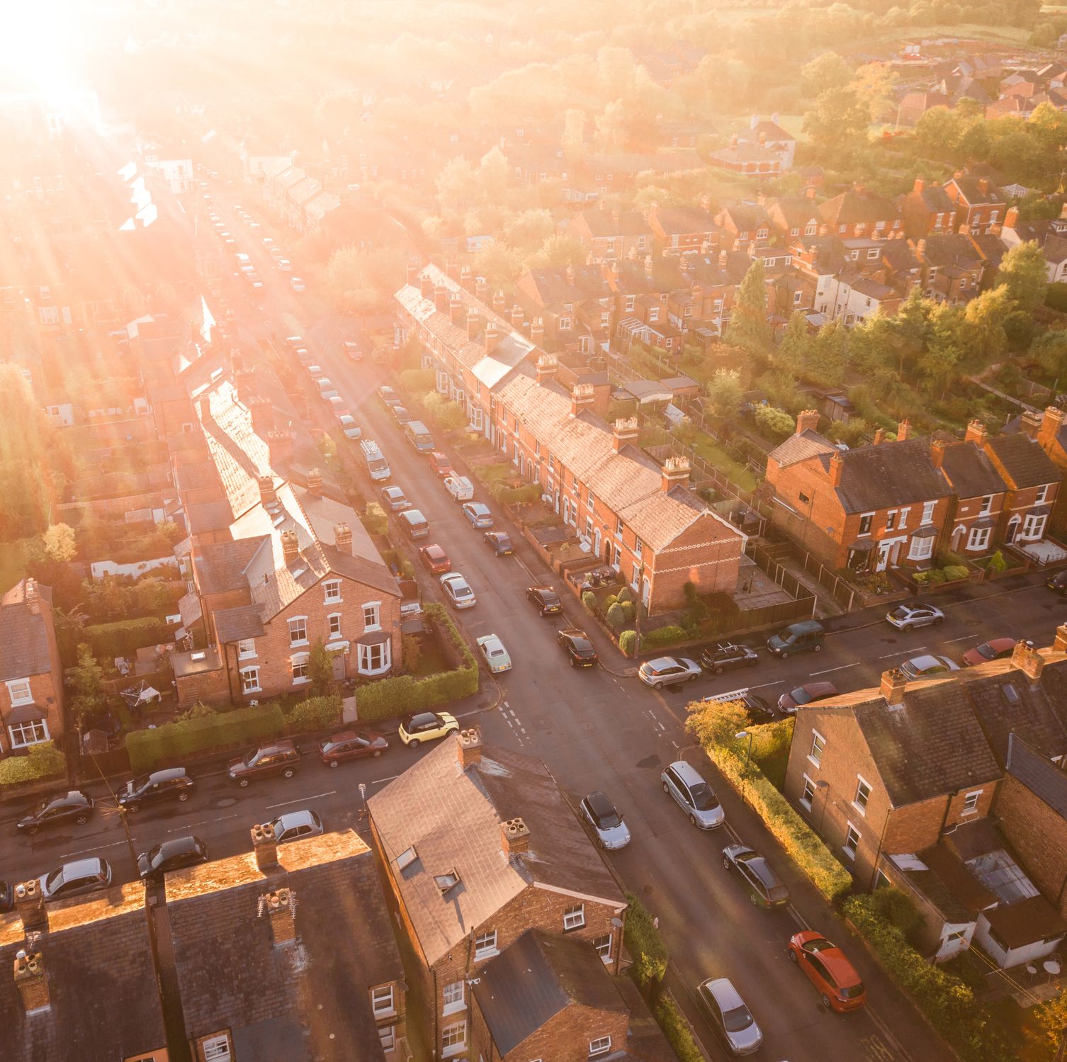 Aerial view of the sun setting over a cross roads in a traditional UK suburb