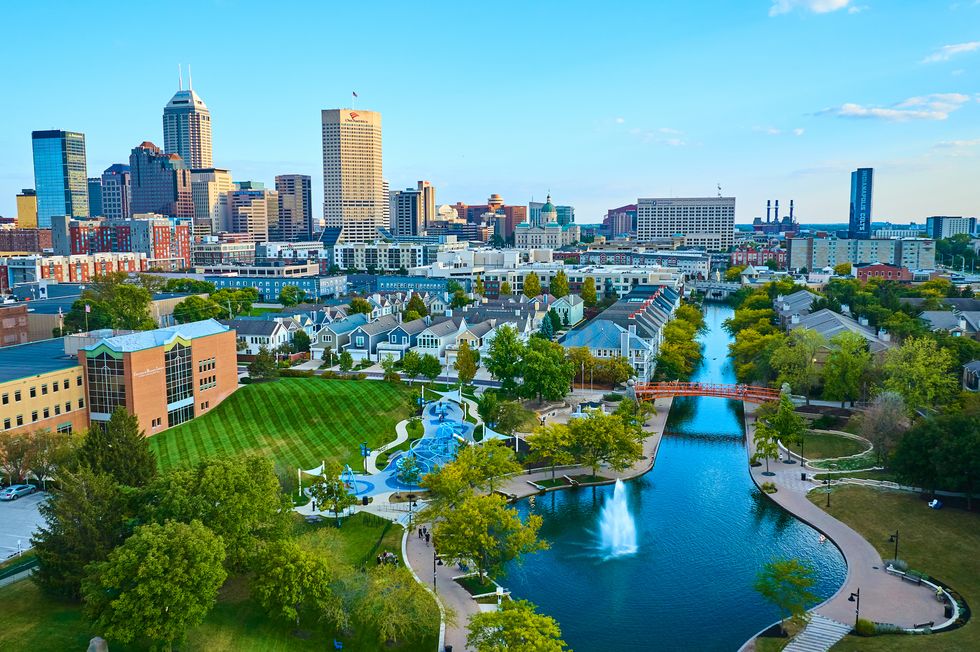 aerial view of urban park with orange bridge and city skyline